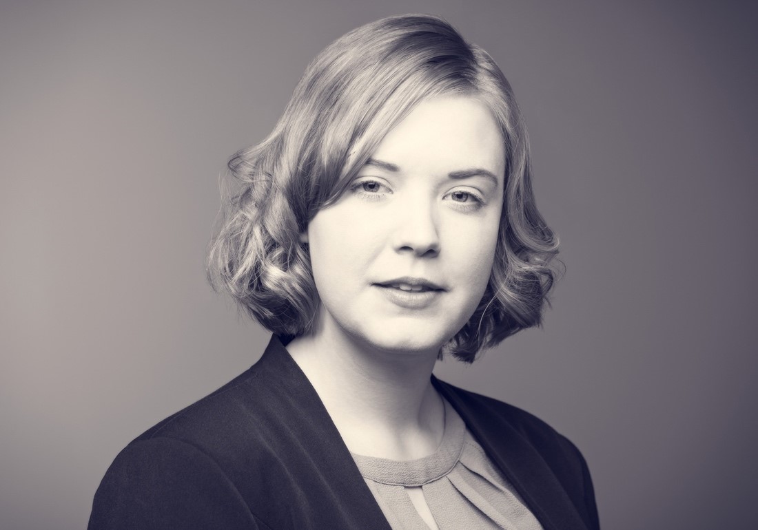 Black and white headshot of Janina Neumann, wearing a blazer jacket and blouse